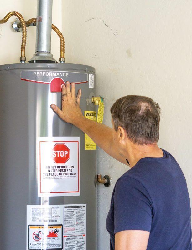 Adult male with hand on newly installed hot water heater
